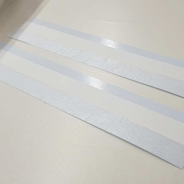 Backing card strips beside steel ruler