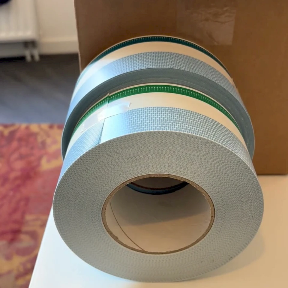 Blue and green printed tape rolls by box