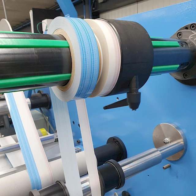 Blue and white tape rolls on rewind shaft