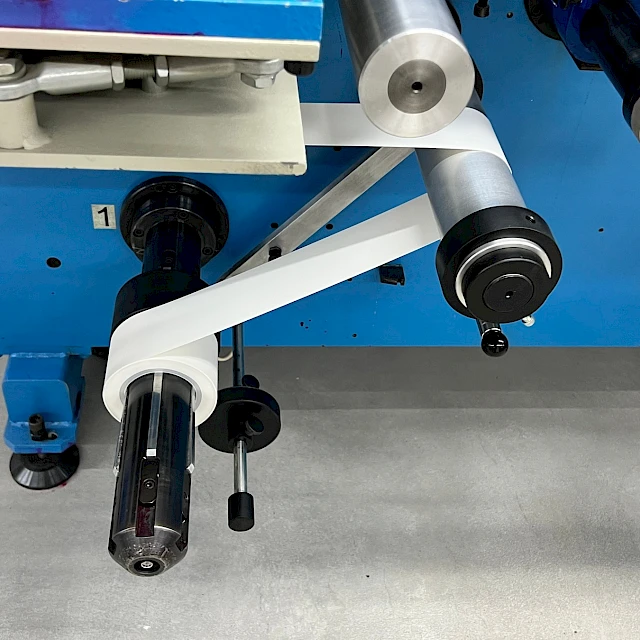 Blue converting machine rewind shaft with white web