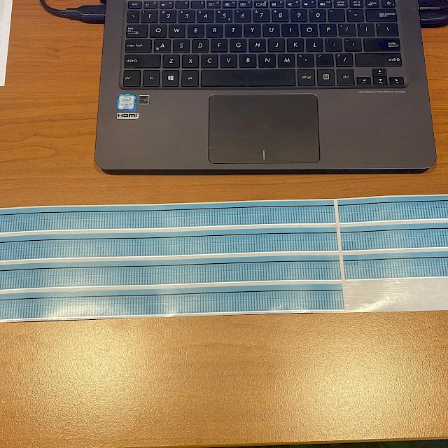 Blue printed strips in front of laptop