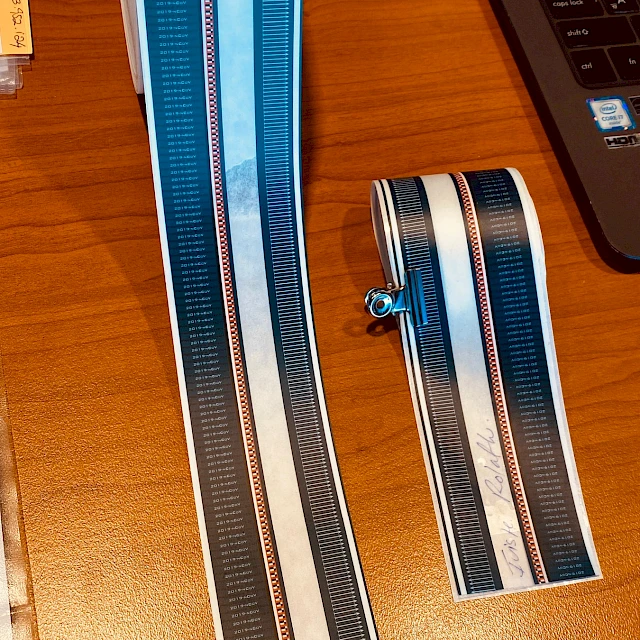 Blue printed tape strips on desk by laptop