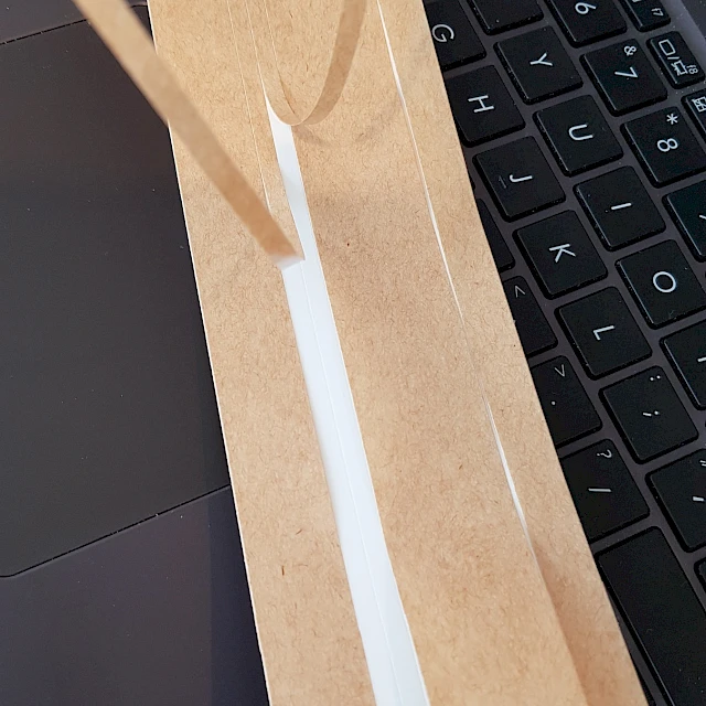 Brown liner peeled from white adhesive strip