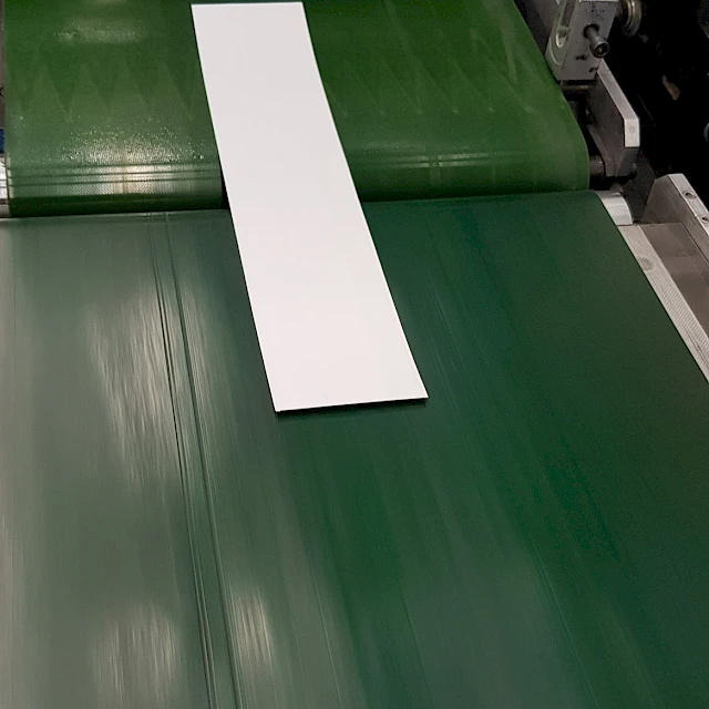 Cut white cards on green conveyor belt