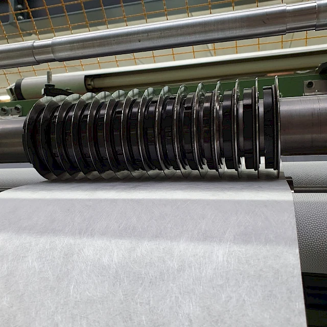 Glass fibre web under slitter knives