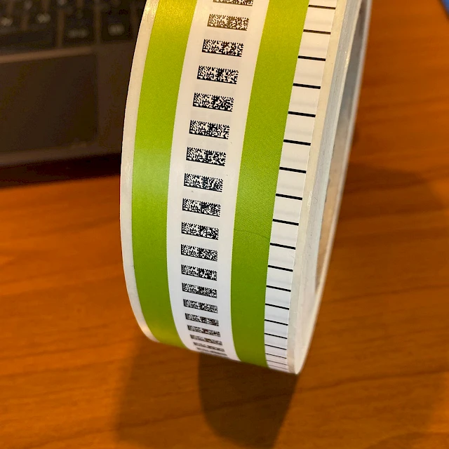 Green and white printed label roll on desk