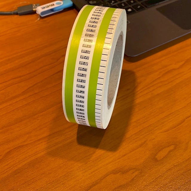 Green barcode printed roll beside laptop