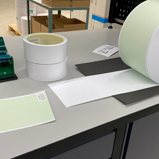 Green printed roll and tape dispensers on workbench