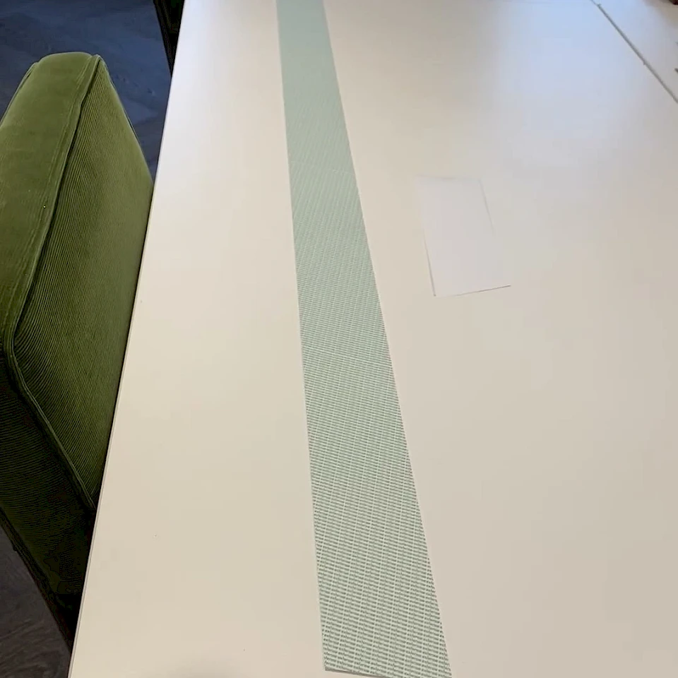 Green printed tape run along conference table