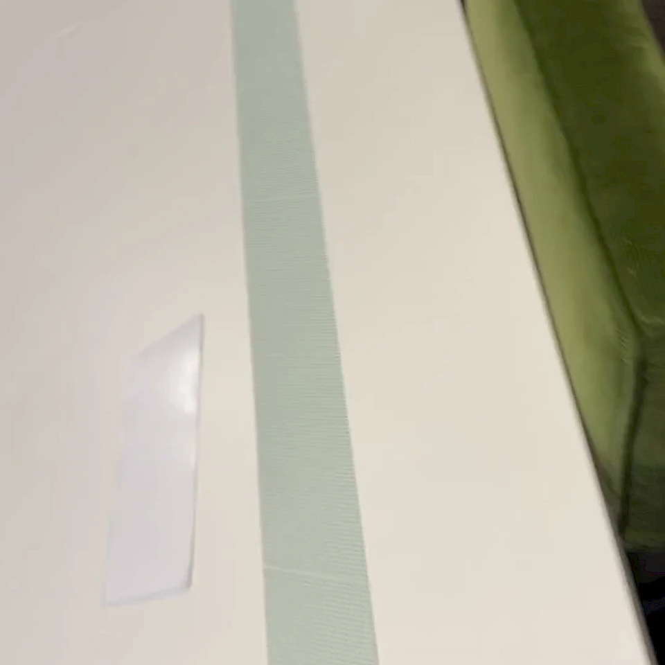 Green printed web strip on white table