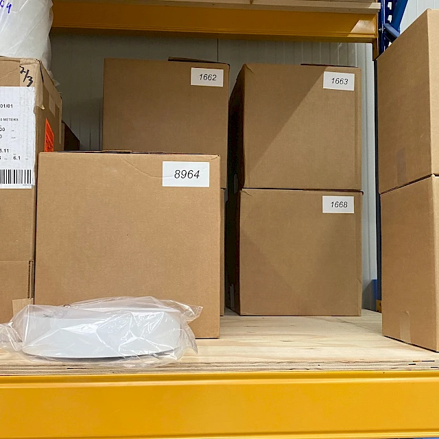 Numbered cartons and rolls on yellow rack shelf