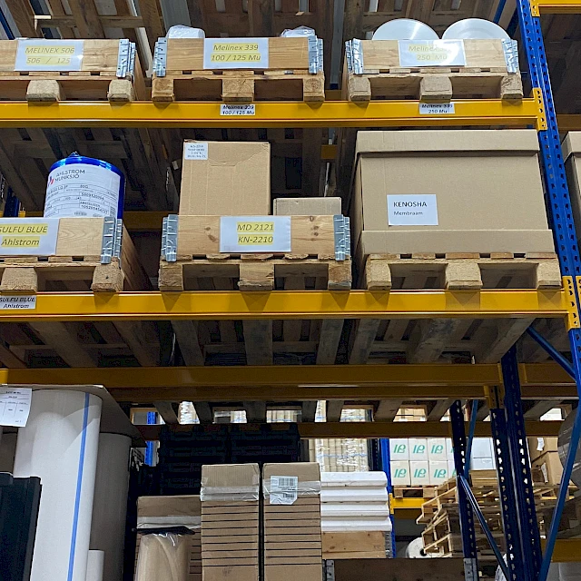 Pallet racking with labelled material rolls and boxes