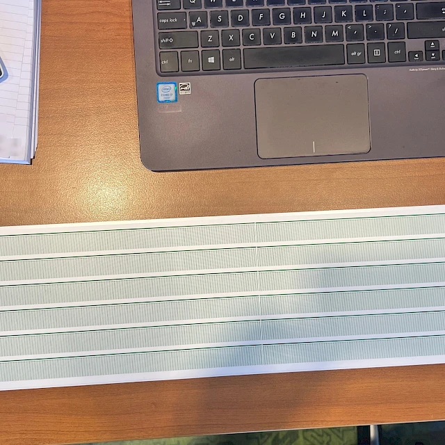 Printed card on desk with laptop and calculator