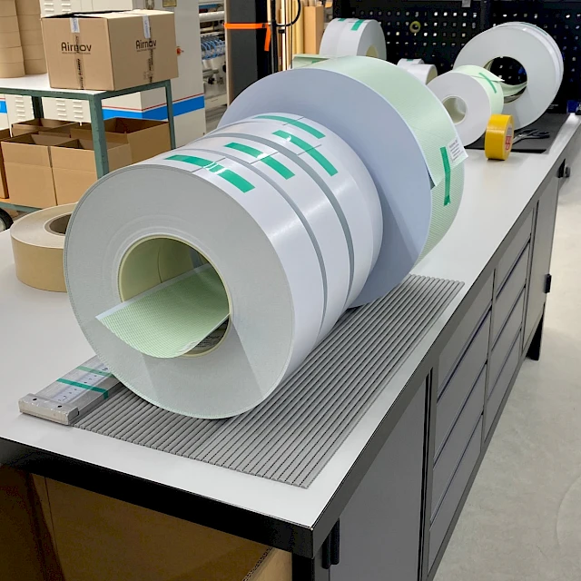 Printed rolls lined up on workbench in hall