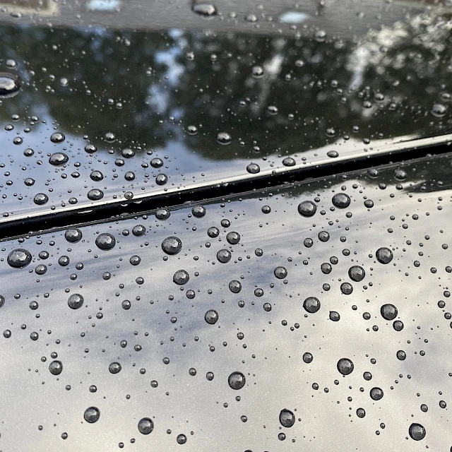 Raindrops on dark car bodywork
