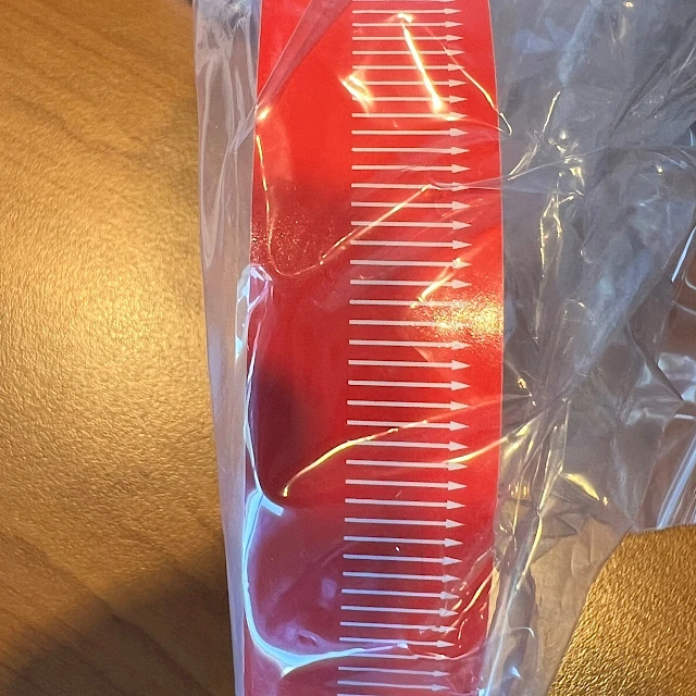 Red scale printed tape roll in bag
