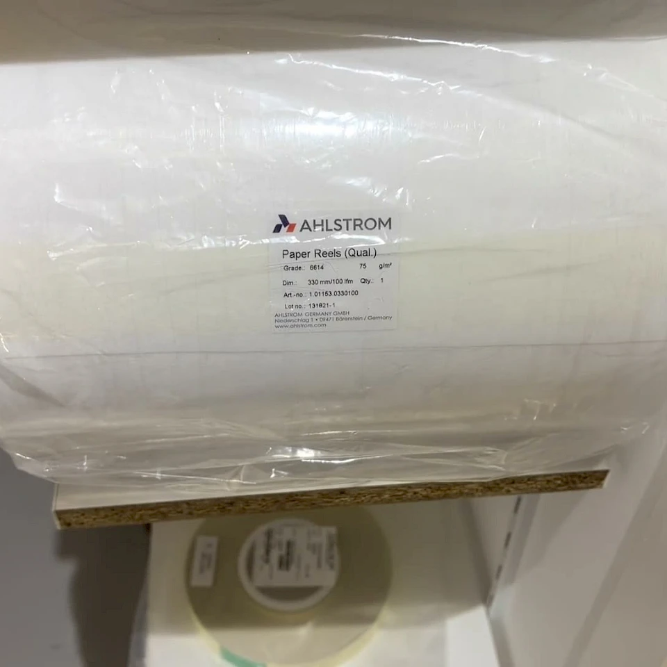 Shrink wrapped absorbent paper reel