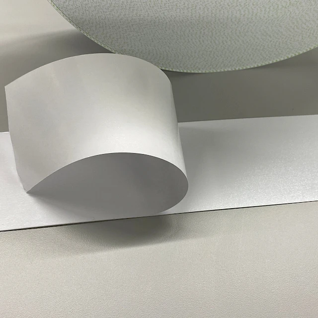 Silver grey film sample curled on bench