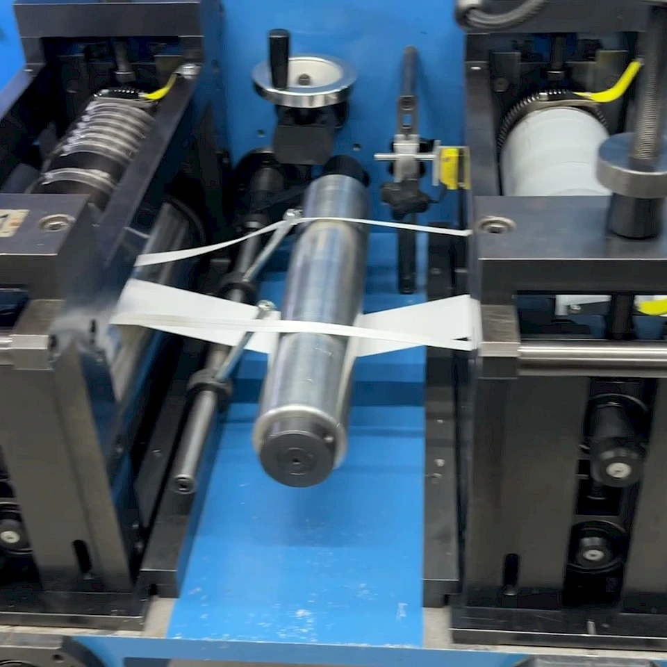 Slitter cutting white strips onto green conveyor