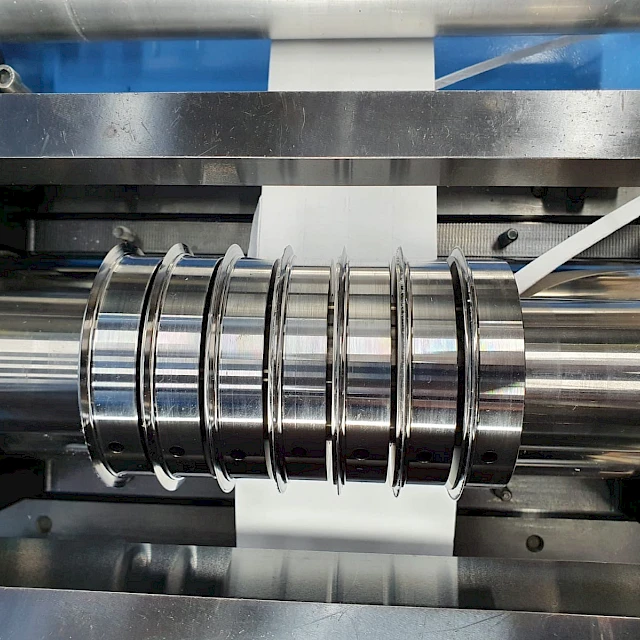 Slitting knives on shaft with web