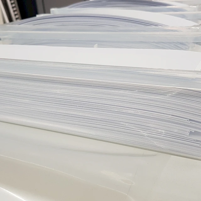 Stack of white backing cards in clear tray