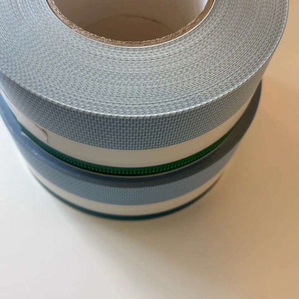 Stacked light blue printed tape rolls