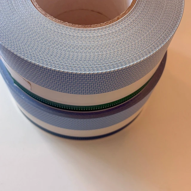 Stacked light blue printed tape rolls