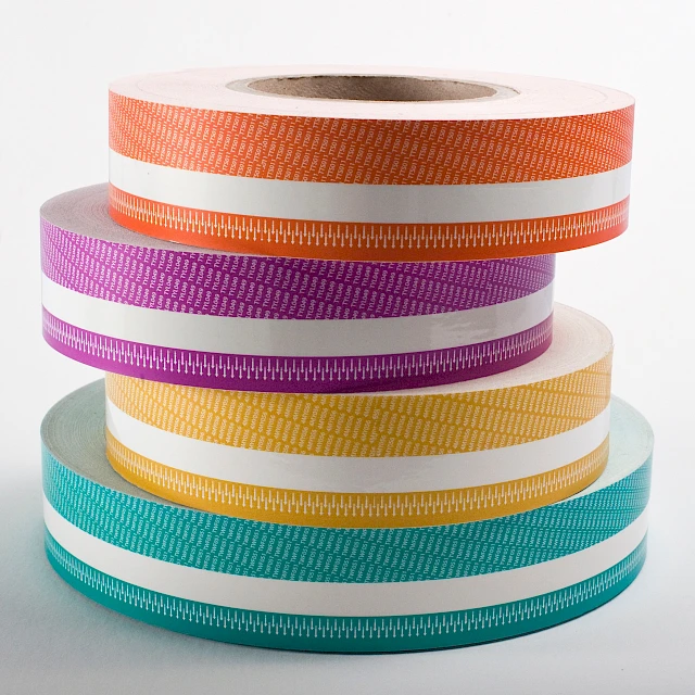 Stacked printed tape rolls orange purple yellow teal