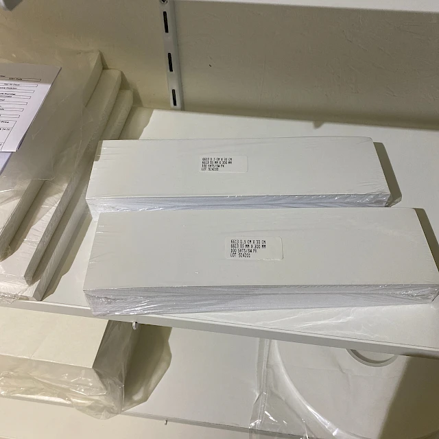Stacked white card packs on shelf