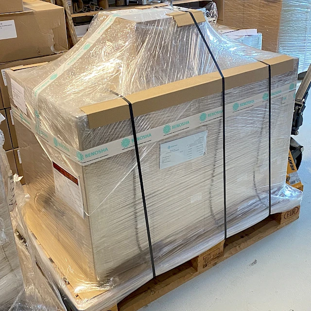 Strapped wrapped pallet of cartons in workshop