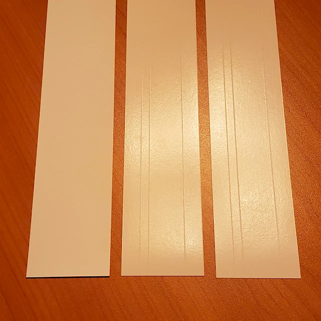 Three white backing card strips