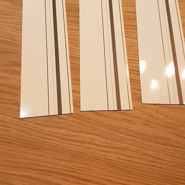 Three white cards with grey stripes on table
