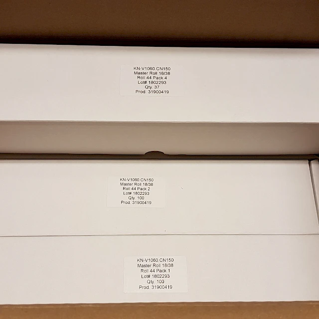 Three white product boxes upright in carton