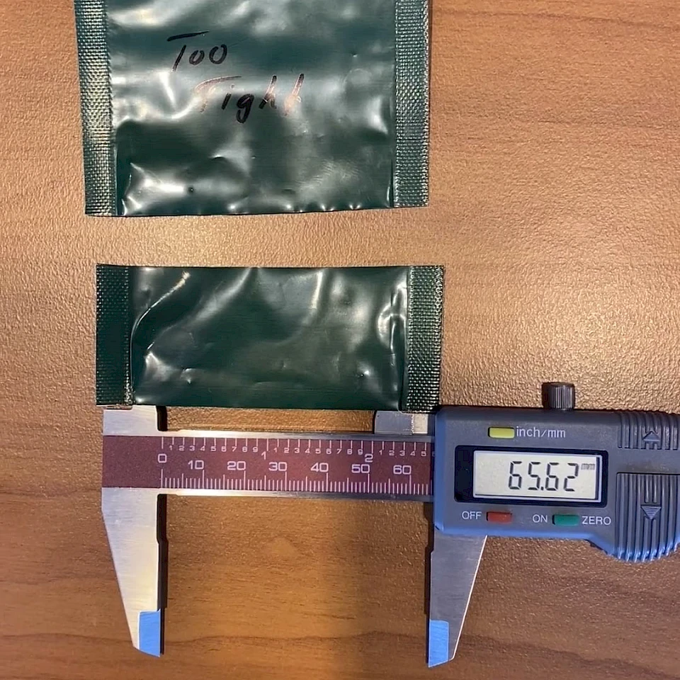 Two green pouches compared with caliper