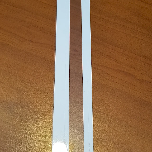 Two narrow white strips on wooden desk