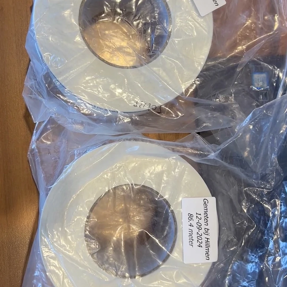 Two white tape rolls in plastic bag with labels