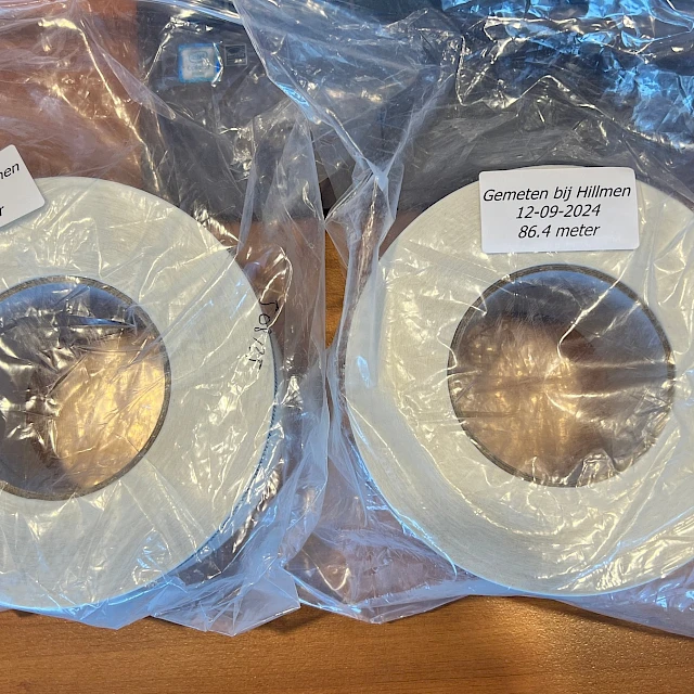 Two white tape rolls in plastic bag with labels