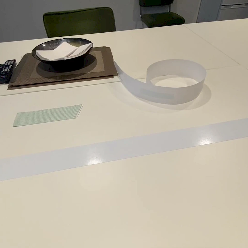 Unrolled white and green film samples on table