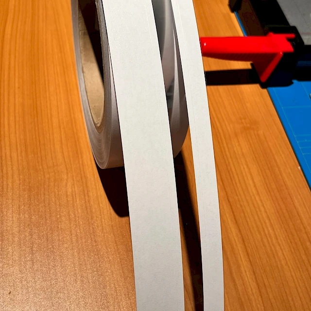 White grey tape roll unwound on desk