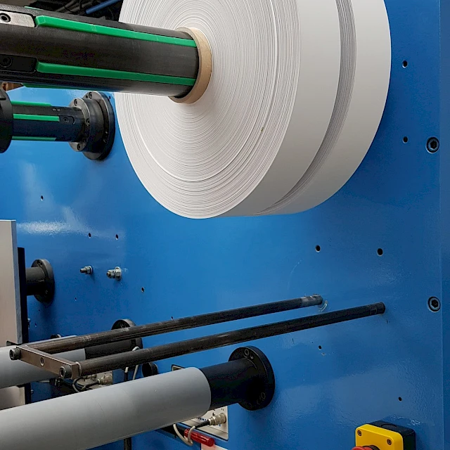 White material roll on blue converting machine mandrel