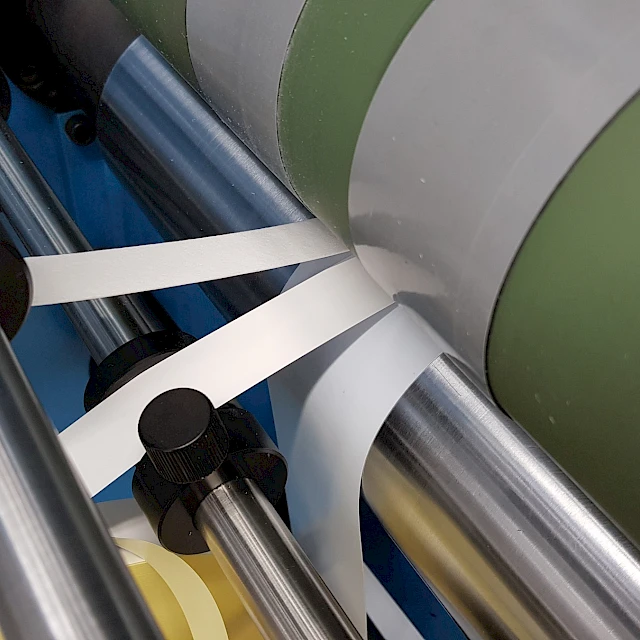 White strips rewinding past green roller