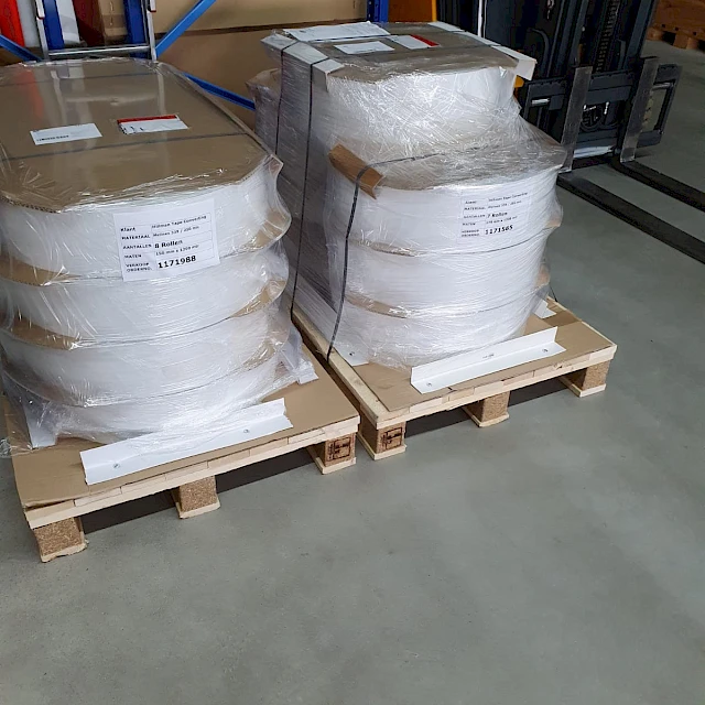 Wrapped material rolls on pallets in warehouse